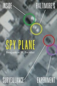 Cover of Spy Plane showing an aerial view of a city block with colored circles around some cars, etc., on the ground